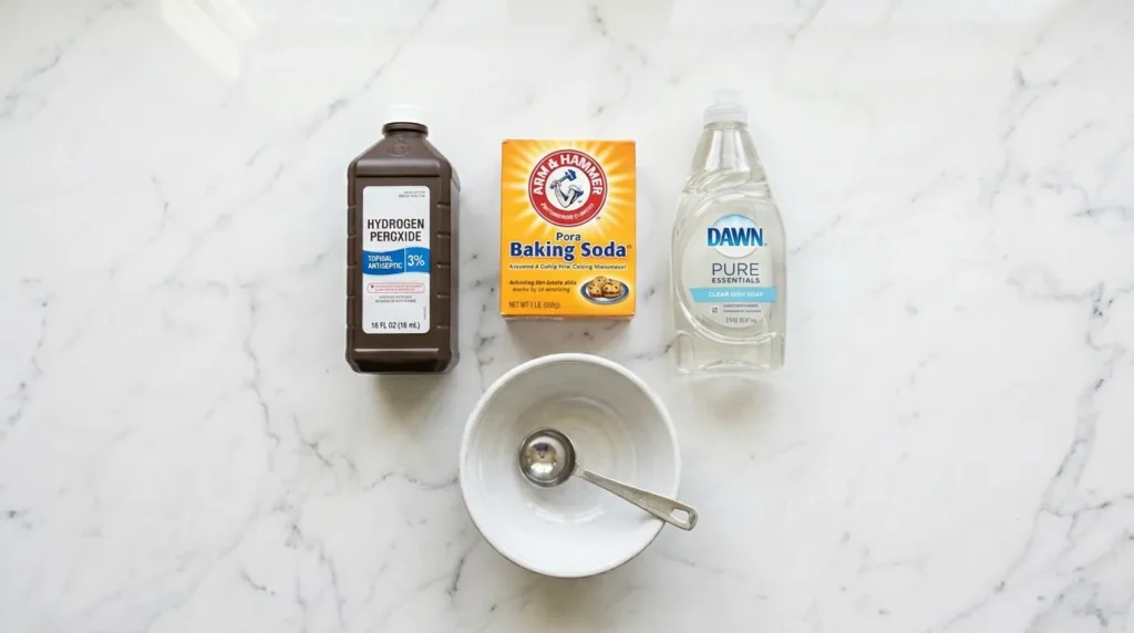 Hydrogen peroxide, baking soda, and dish soap arranged on a white surface for a DIY cat urine stain remover.